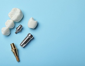 The parts of dental bridges and implants against a blue background