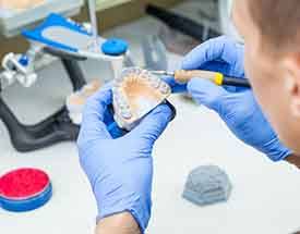 Lab technician carving dentures